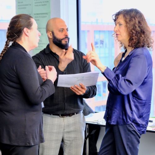 Two women and one man converse